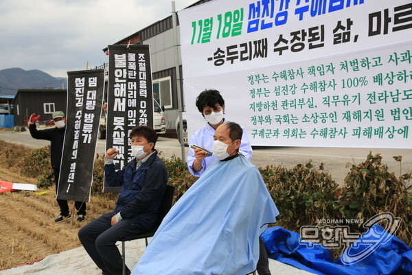 지난달 18일 전남 구례군 구례오일장에서 열린 '섬진강 수해참사 100일 피해자 총궐기 대회'에서 대책위 대표들이 삭발을 하고 있다.
