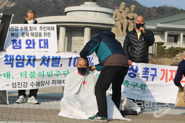 섬진강 수해참사 피해자 구례군대책위원회가 7일 청와대 앞에서 책임자 처벌 및 100% 피해보상 촉구 기자회견을 열고 삭발을 하고 있다.