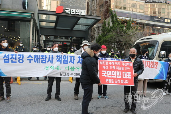 섬진강 수해참사 피해자 구례군비상대책위원회가 7일 여의도 국민의힘 당사 앞에서 배상 문제 해결을 위한 대표 면담 요청 협의서를 국민의힘 관계자에게 전달하고 있다.